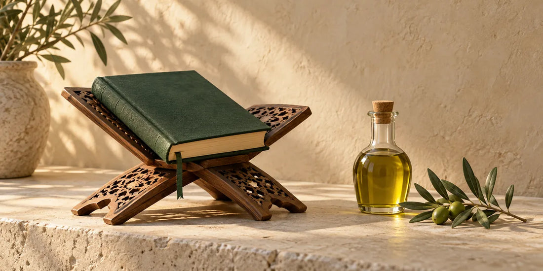 Closed green Qur'an on a carved wooden stand beside a small bottle of golden-green olive oil