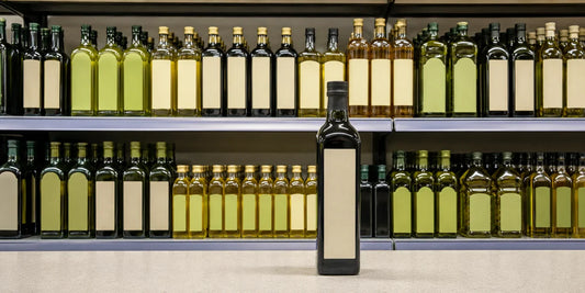Supermarket olive oil aisle with a dark glass bottle stood forward as the chosen oil