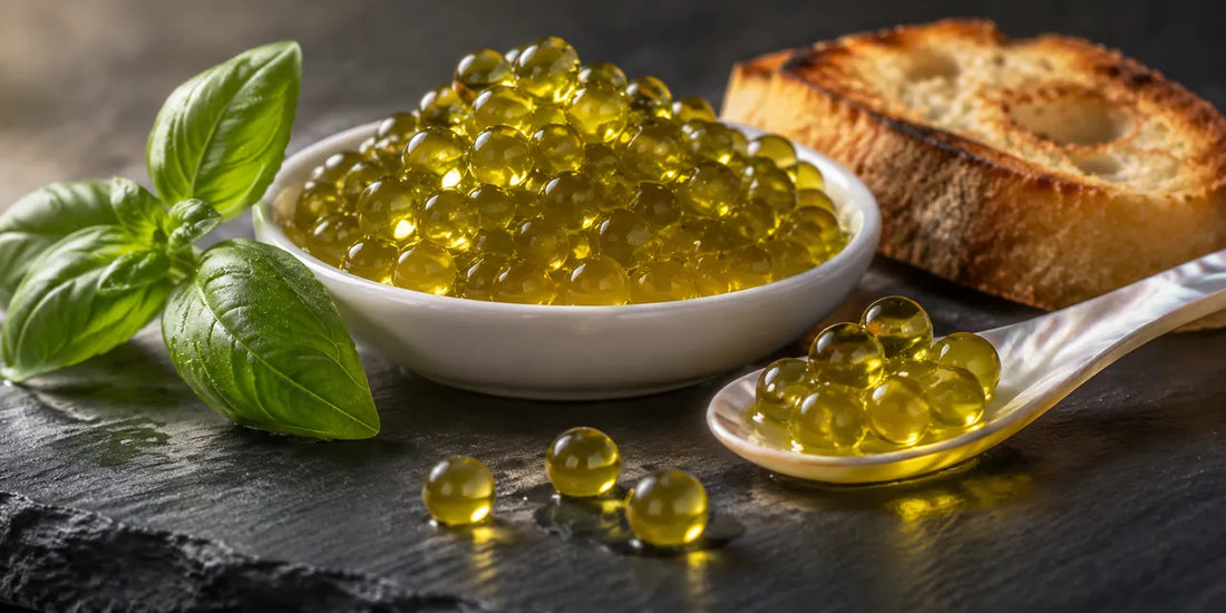 Glistening golden-green olive oil pearls in a small dish and on a mother-of-pearl spoon on dark slate